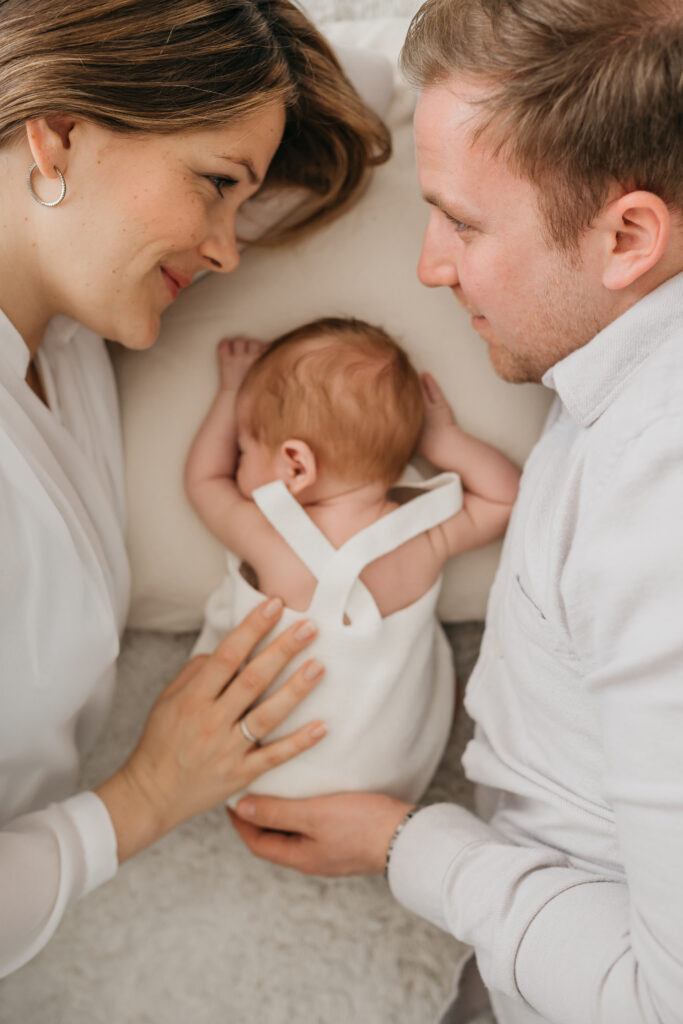 Eine Familie mit einem Neugeborenen auf dem Bett. Babyshooting Karlsruhe